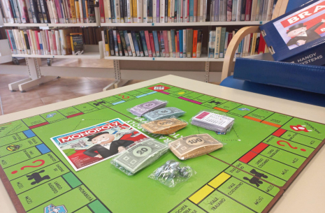 Un tavolo in biblioteca con una versione italiana del gioco da tavolo Monopoly 
